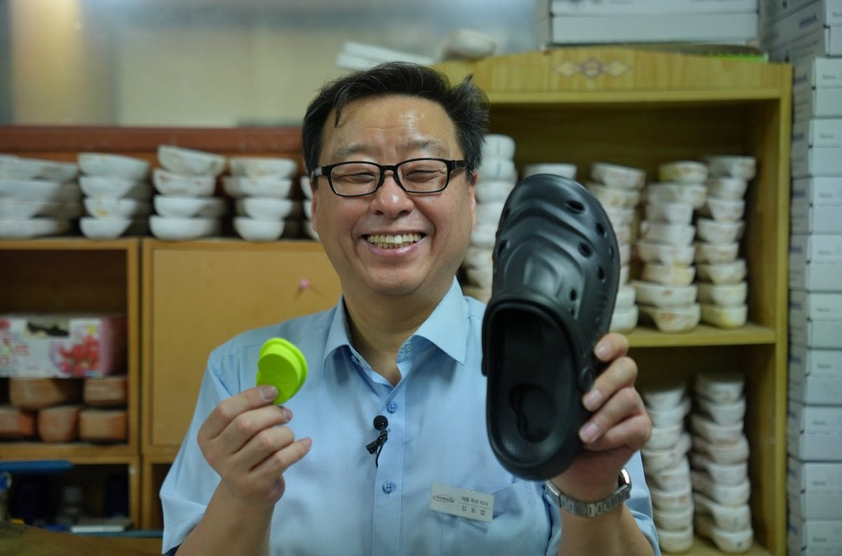 Dong-yeop Kim holding a PIPU clog and heel pad in his workshop