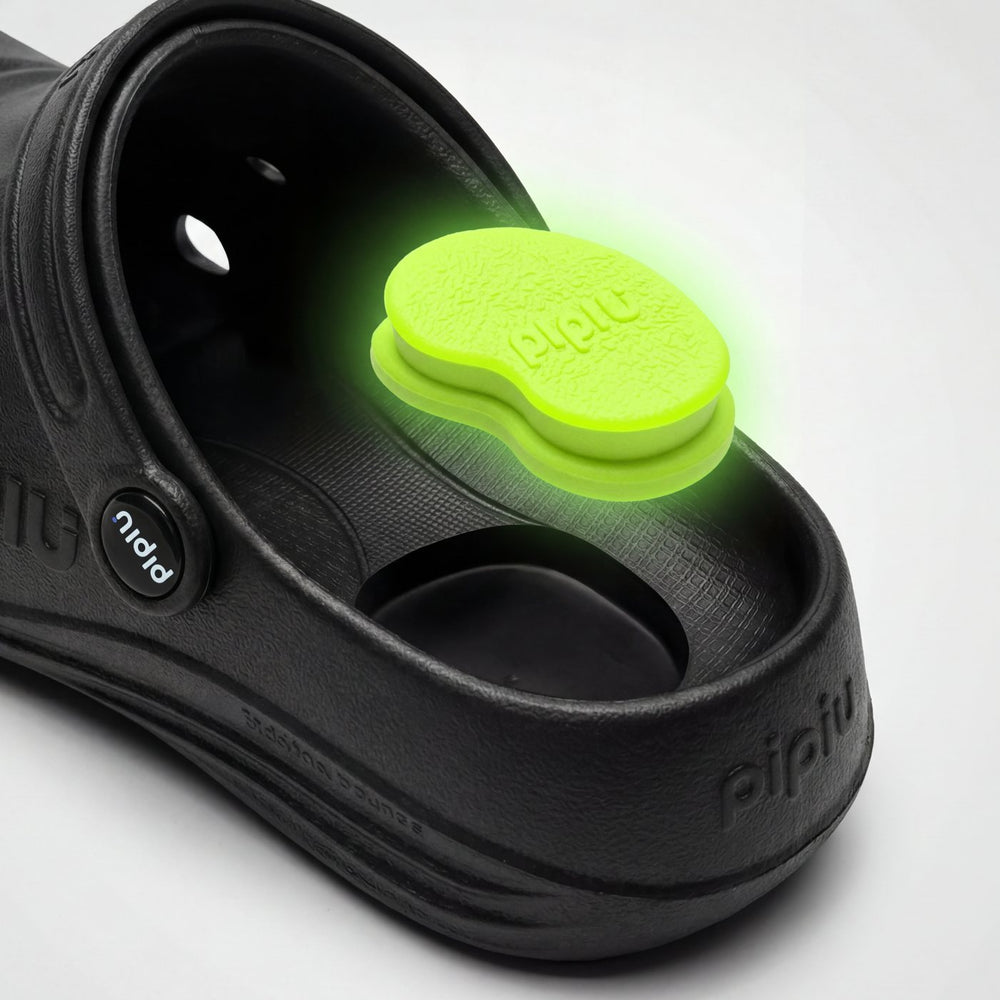 The lime green Peanut Pad sitting in the heel of a black pipiu clog